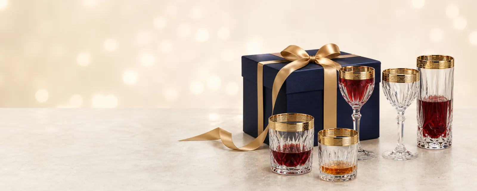 Geschenkverpackung und geschliffene Gläser mit Goldrand